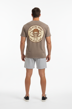 Full body back view of male model wearing brown Ten Attire Rugby skull badge tee